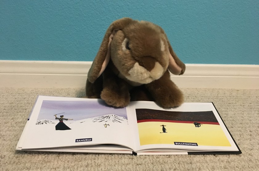 Caramel is pointing at the pages of Penguins Hate Stuff where we learn that penguins hate samurai and bullfighting. 