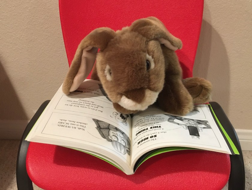 Caramel is reading The Bad Guys in Mission Unpluckable by Aaron Blabey.