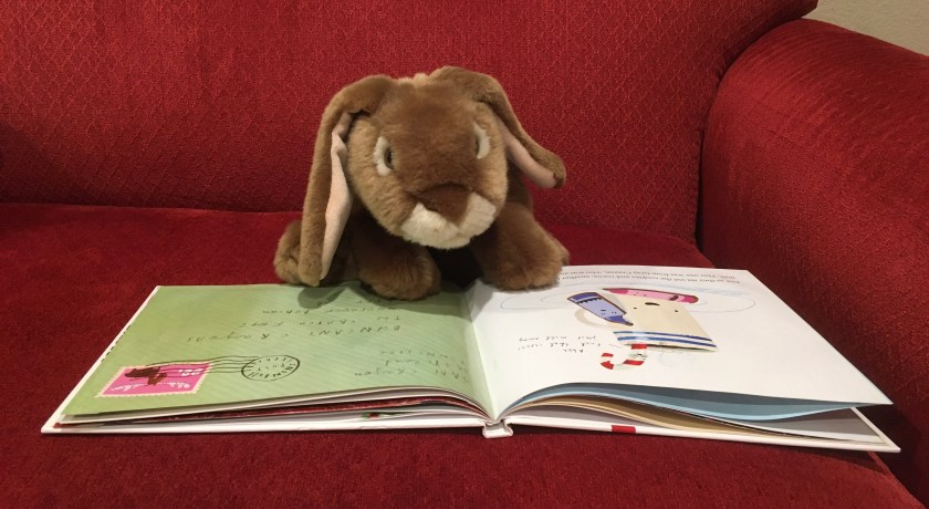 Caramel is reading The Crayons' Christmas, written by Drew Daywalt and illustrated by Oliver Jeffers.