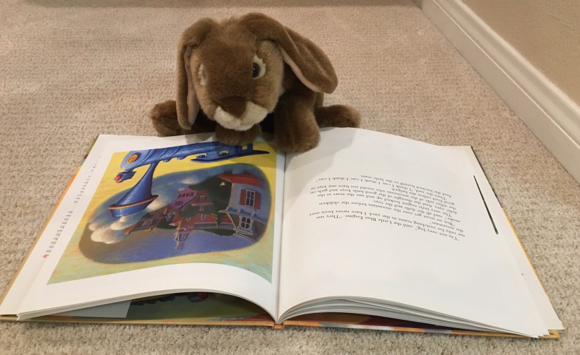 Caramel is reading The Little Engine That Could, by Watty Piper, with new art by Loren Long.