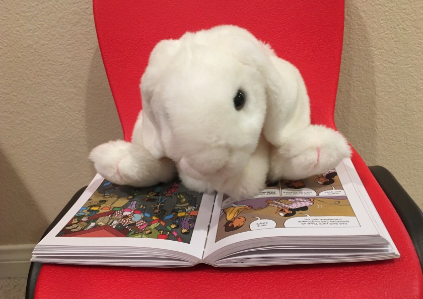 Marshmallow is reading Ghosts by Raina Telgemeier.