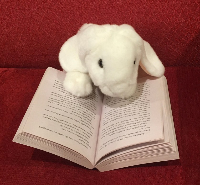 Marshmallow is reading Poached by Stuart Gibbs.
