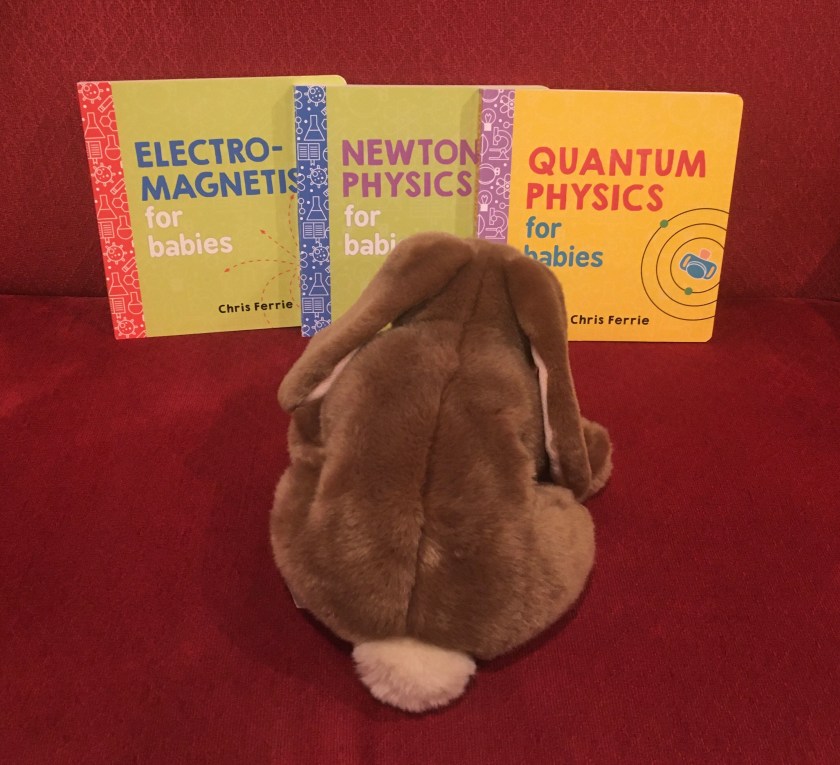 Caramel is looking at Electromagnetism for Babies, Newtonian Physics for Babies, and Quantum Physics for Babies, all written by Chris Ferrie.