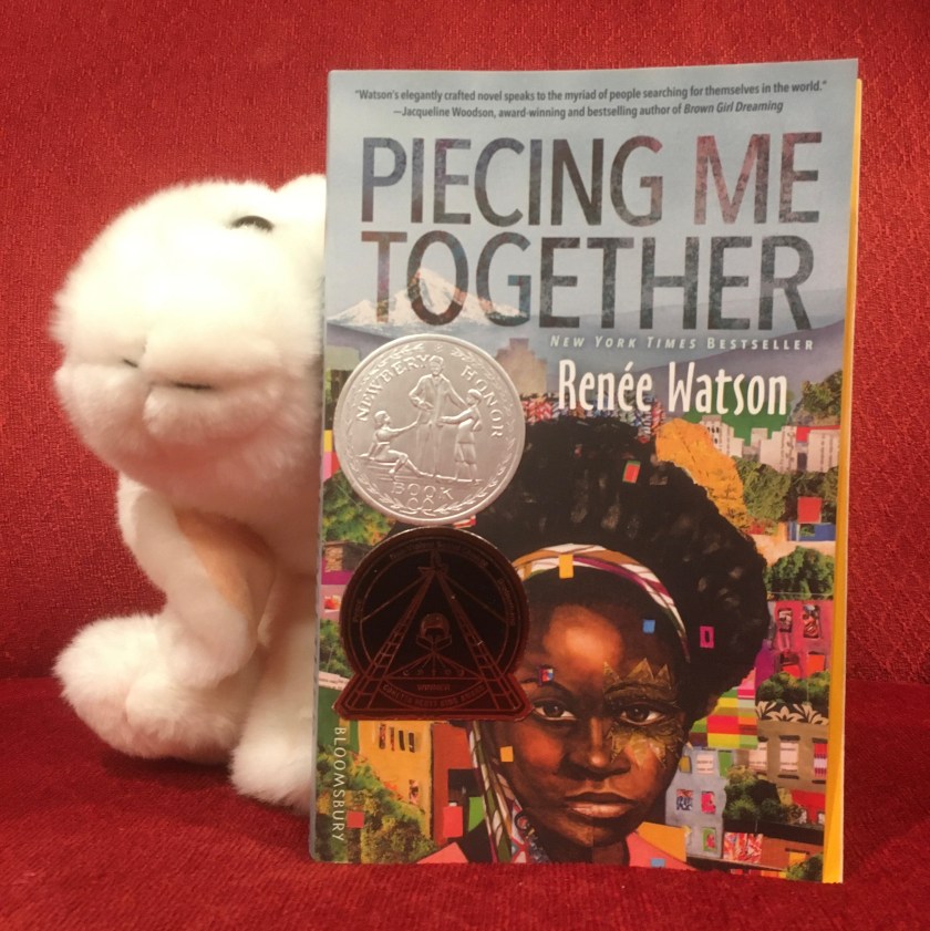 Marshmallow is reading Piecing Me Together by Renée Watson.
