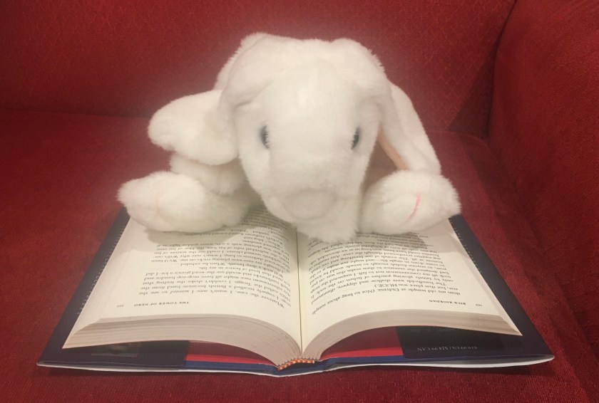 Marshmallow is reading The Tower of Nero (Book 5 of the Trials of Apollo Series) by Rick Riordan.
