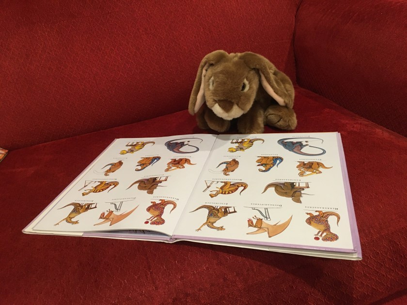 Caramel is looking at the full cast of How Do Dinosaurs Go To School? (2007),  written by Jane Yolen and illustrated by Mark Teague. 