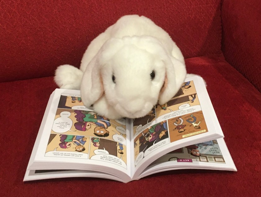 Marshmallow is reading Drama by Raina Telgemeier.
