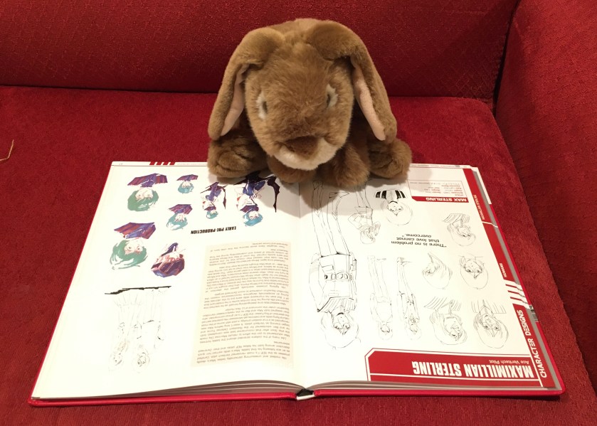 Caramel is reading about Max Sterling, his favorite character in the series, in Robotech Visual Archive: The Macross Saga, edited by Matt Moylan.