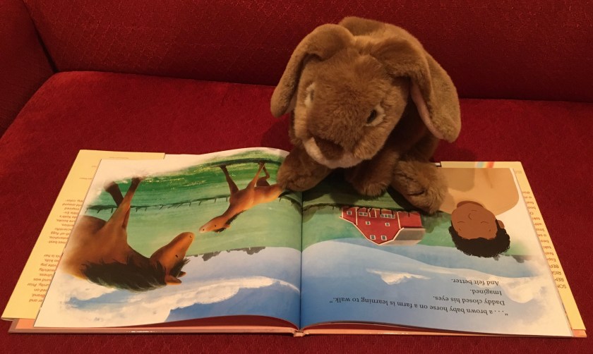 Caramel is reading Somewhere, Right Now, written by Kerry Docherty and illustrated by Suzie Mason.