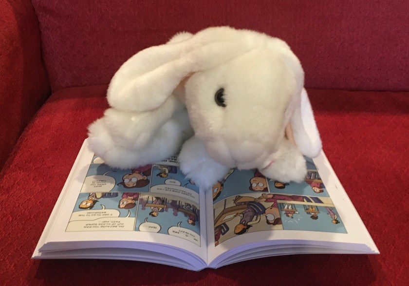 Marshmallow is reading Guts by Raina Telgemeier.