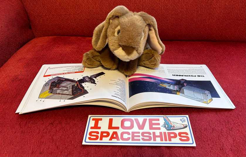 Caramel is reading Kepler's Intergalactic Guide to Spaceships by Jake Parker. 