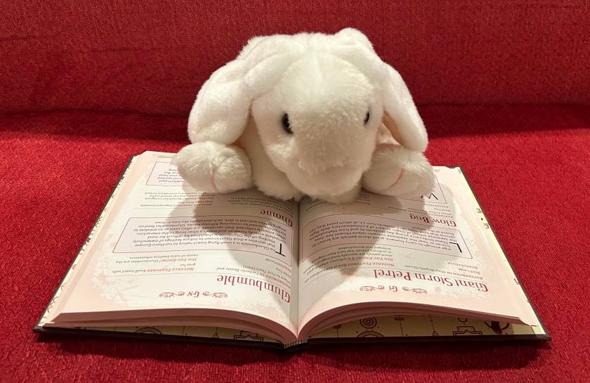 Marshmallow is reading The Unofficial Harry Potter Bestiary: MuggleNet's Complete Guide to the Fantastic Creatures of the Wizarding World by Media Lab Books.