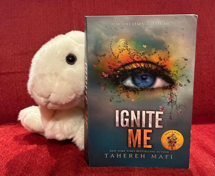 Marshmallow is posing once again with her copy of Ignite Me by Tahereh Mafi.