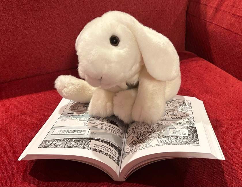 Marshmallow is reading Fun Home: A Family Tragicomic by Alison Bechdel.