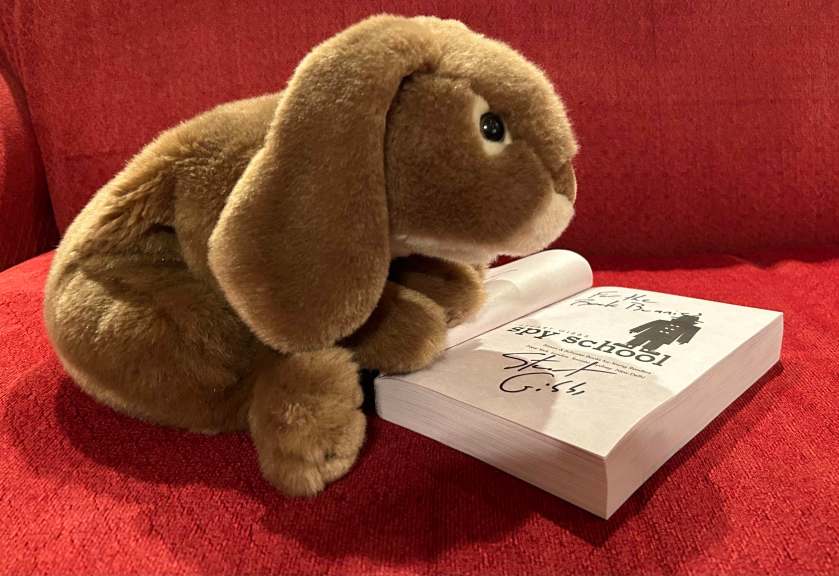 Caramel is looking happily at the autographed title page of Spy School by Stuart Gibbs.