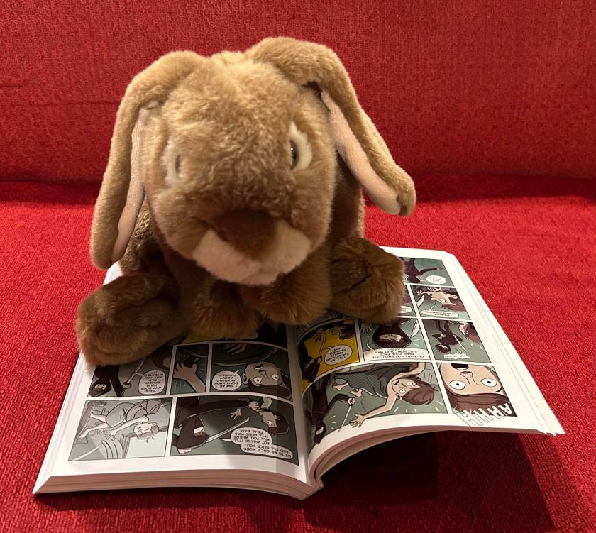 Caramel is reading Spy School: The Graphic Novel, written by Stuart Gibbs and illustrated by Anjan Sarkar.