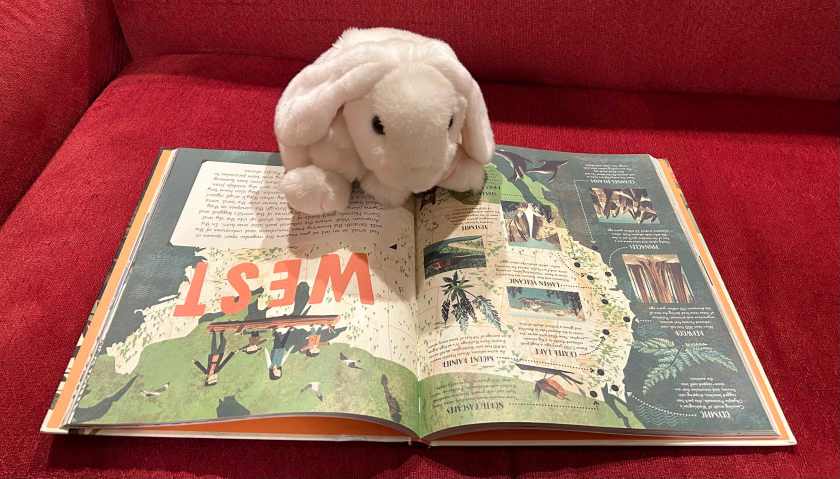 Marshmallow is reading National Parks of the U.S.A., written by Kate Siber and illustrated by Chris Turnham.