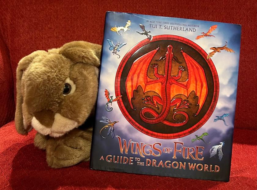 Caramel reviews Wings of Fire: A Guide to the Dragon World, written by Tui T. Sutherland and illustrated by Joy Ang, with additional art from Mike Schley and Maarta Laiho.