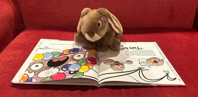 Caramel is reading Ricky, The Rock That Couldn't Roll, written by Mr. Jay and illustrated by Erin Wozniak.