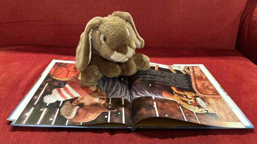 Caramel is reading Sugarbush Spring, written by Marsha Wilson Chall and illustrated by Jim Daly.