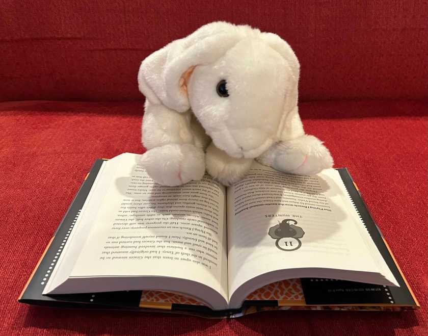 Marshmallow is reading All Ears by Stuart Gibbs.