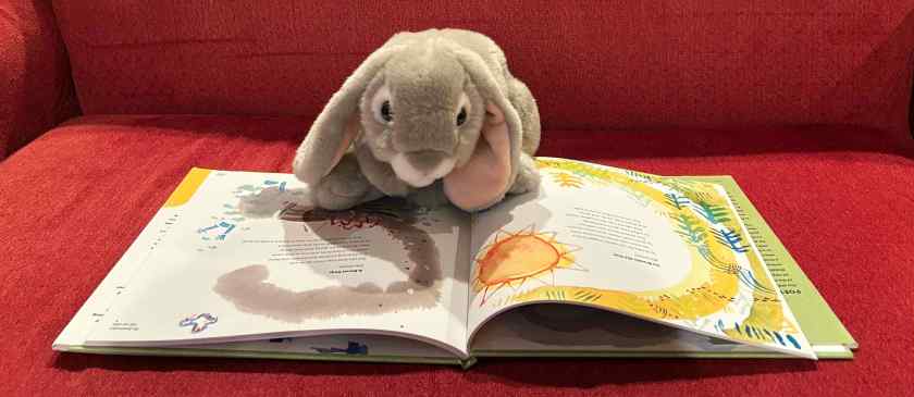 Sprinkles is reading The Death of the Hat: A Brief History of Poetry in Fifty Objects by Paul B. Janeczko and Chris Raschka.