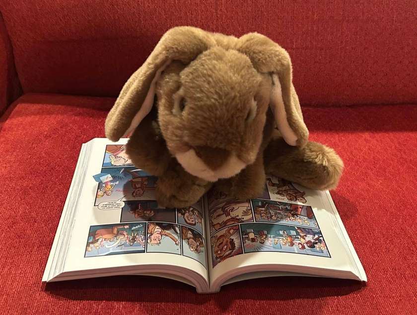 Caramel is reading Space Case: The Graphic Novel, written by Stuart Gibbs and illustrated by Ward Jenkins.