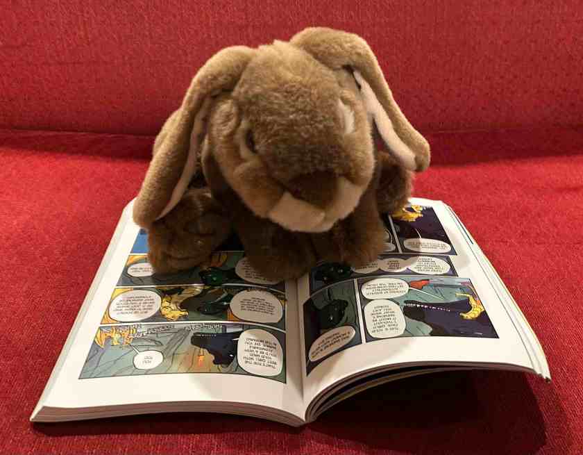 Caramel is reading Talons of Power: The Graphic Novel (Book Nine of Wings of Fire), written by Tui Sutherland and illustrated by Mike Holmes.